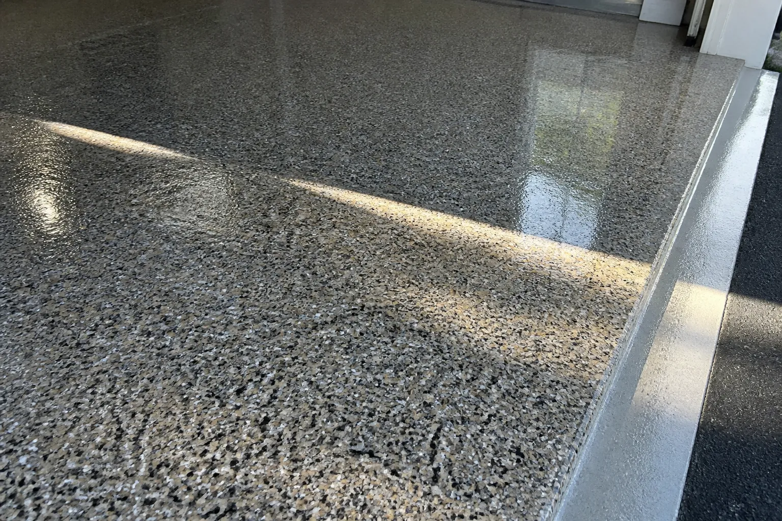 Close-up of decorative flake epoxy garage floor coating in a Tampa home