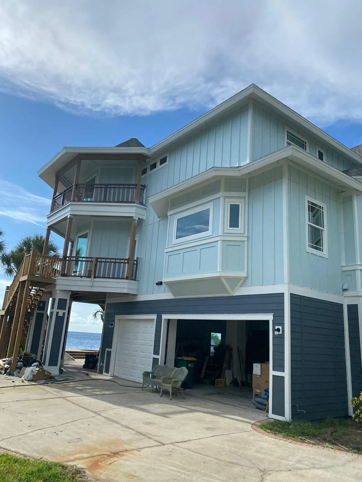 Two-story gray home exterior painting in progress
